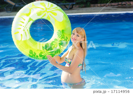 Pregnant woman with green rubber ring in swimming pool Pregnant woman with green rubber ring in swimming pool 17114956