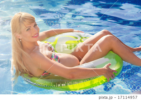 Pregnant woman is swimming with rubber ring in pool Pregnant woman is swimming with rubber ring in pool 17114957