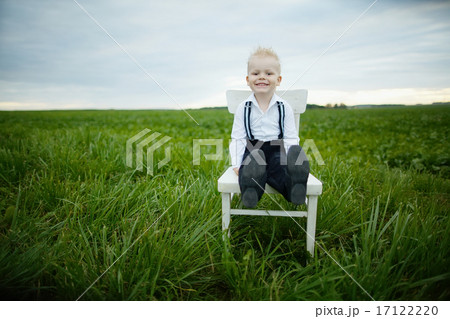 boy sits on chair in the field 17122220