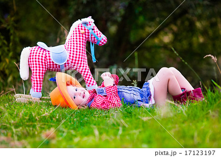 Little girl playing with toy horse in cowboy costume 17123197