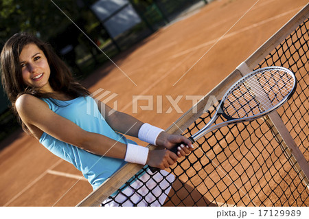Girl playing tennis on the court 17129989