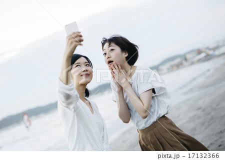 海で写真を撮る女性二人 海で写真を撮る女性二人 17132366