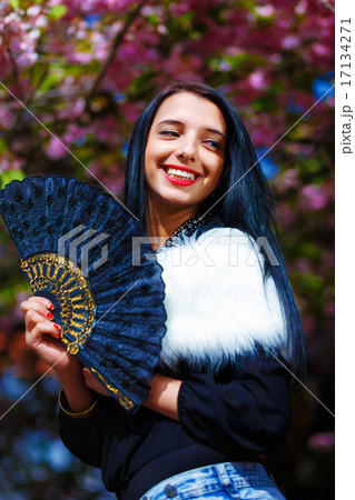 Beautiful Woman with flowers glamour white fur and black fan in hand. 17134271