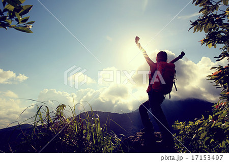 cheering woman hiker open arms at mountain peak  17153497