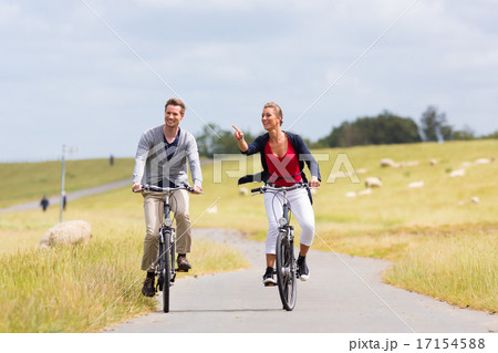 Couple having sea coast bicycle tour at levee 17154588