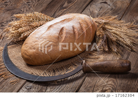 Bread, ears and sickle on old boards 17162304