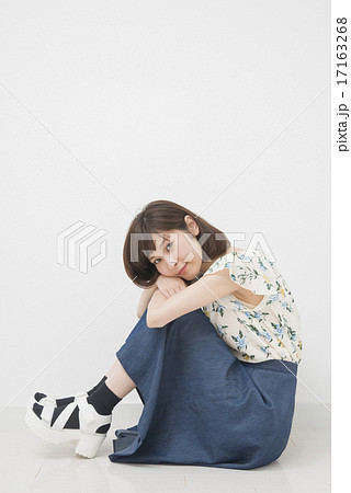 膝を抱えて座る女性の写真素材