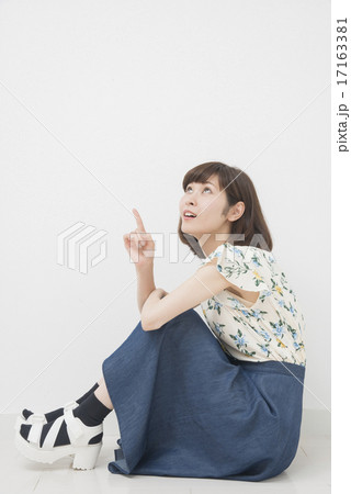 膝を抱えて座る女性の写真素材