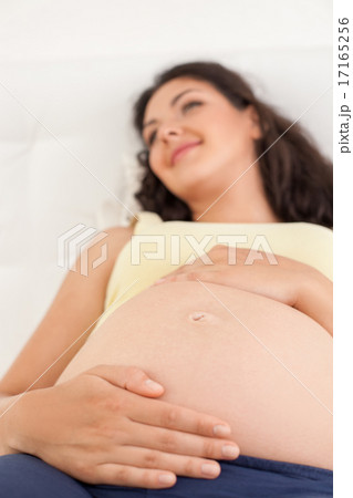 Cheerful healthy pregnant woman is relaxing in bedroom 17165256