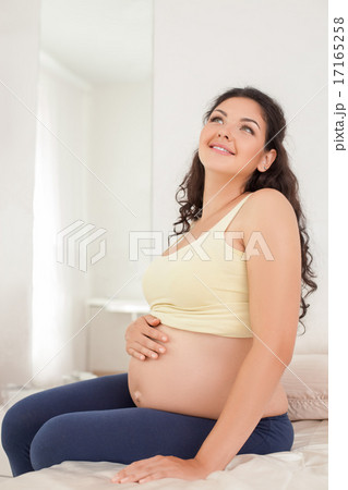 Pretty young expectant mother is dreaming about future 17165258