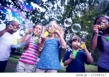 Children playing with bubble wand in the park 17166317