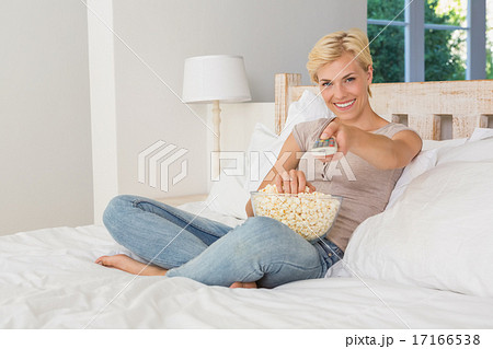 Portrait blonde woman watiching TV and eating pop corn Portrait blonde woman watiching TV and eating pop corn 17166538