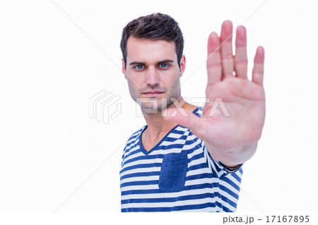 Handsome hipster looking at camera and showing stop sign with ha 17167895