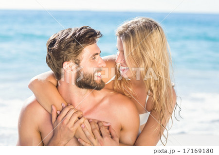 Happy couple relaxing together in the sand 17169180
