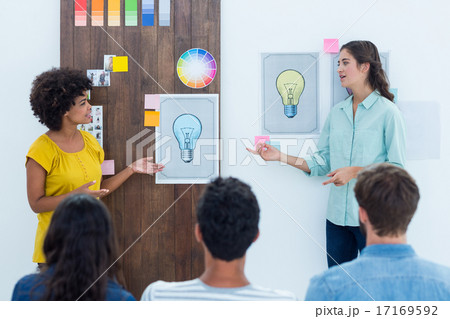 Casual young businesswoman giving presentation to colleagues Casual young businesswoman giving presentation to colleagues 17169592