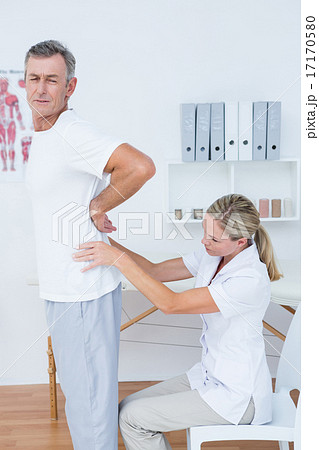 Doctor examining her patient back Doctor examining her patient back 17170580