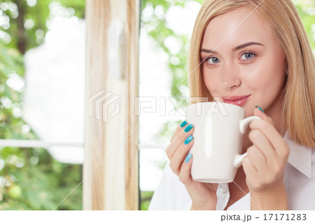 Beautiful young girl is resting on windowsill Beautiful young girl is resting on windowsill 17171283