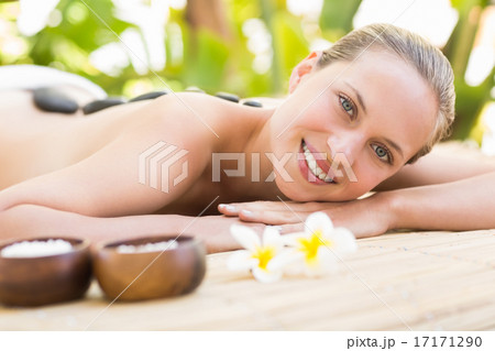 Beautiful woman receiving stone massage at spa center Beautiful woman receiving stone massage at spa center 17171290