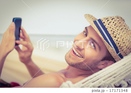 Handsome man texting on the hammock 17171348