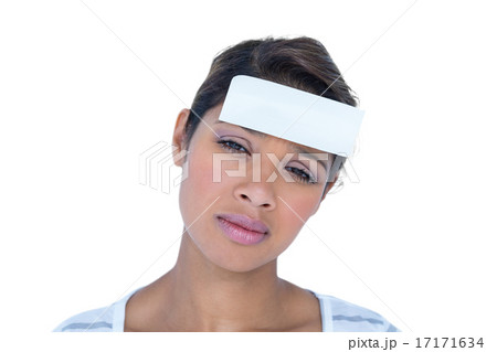 Pretty brunette looking at camera with paper on head Pretty brunette looking at camera with paper on head 17171634