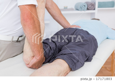 Physiotherapist doing leg massage to his patient 17171803
