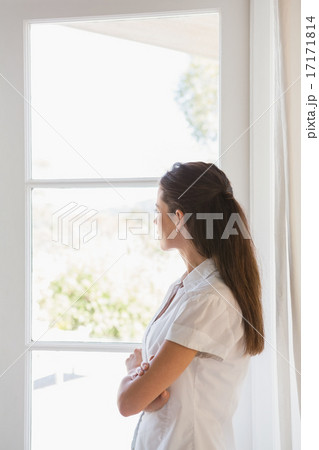 Beautiful brunette woman looking out in the window Beautiful brunette woman looking out in the window 17171814