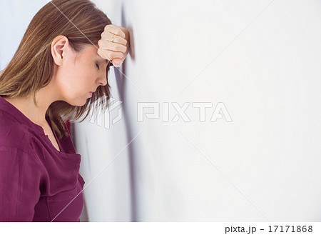 Depressed woman leaning her head against a wall Depressed woman leaning her head against a wall 17171868