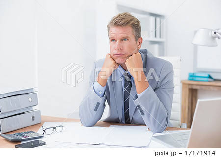 Worried businessman sitting at work Worried businessman sitting at work 17171914