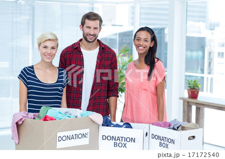Smiling young friends volunteers separating clothes 17172540