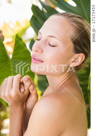 Beautiful blonde smiling at camera behind leaf 17173455