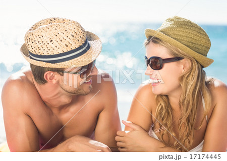 Happy couple relaxing together in the sand 17174445