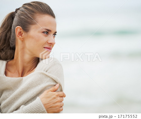 Young woman in sweater on beach looking on copy space Young woman in sweater on beach looking on copy space 17175552