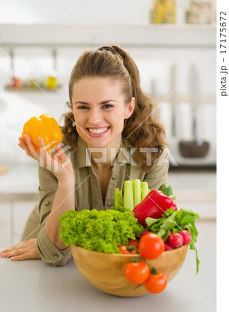 Portrait of happy young housewife with plate of fresh vegetables 17175672