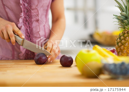 Closeup on young housewife cutting plums Closeup on young housewife cutting plums 17175944