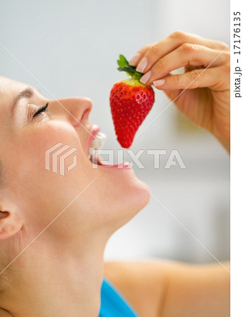 Portrait of young woman eating strawberry 17176135