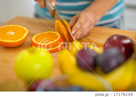 Closeup on young woman cutting orange Closeup on young woman cutting orange 17176239