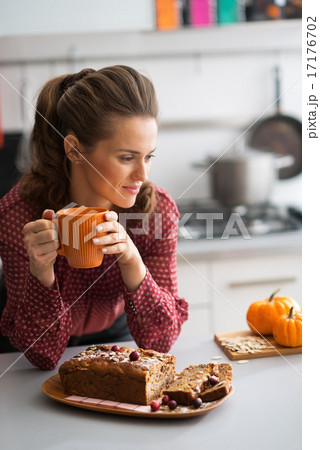 Young housewife drinking tea with freshly baked pumpkin bread wi Young housewife drinking tea with freshly baked pumpkin bread wi 17176702