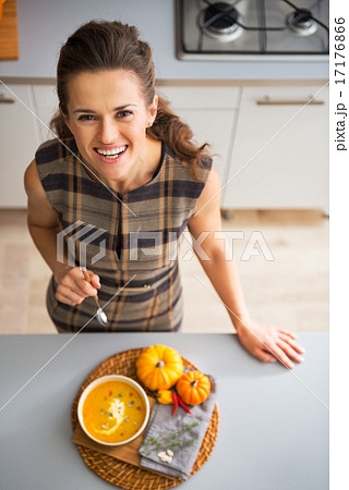 Portrait of happy young housewife eating pumpkin soup Portrait of happy young housewife eating pumpkin soup 17176866