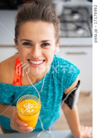 Portrait of happy fitness young woman with pumpkin smoothie in k 17176962
