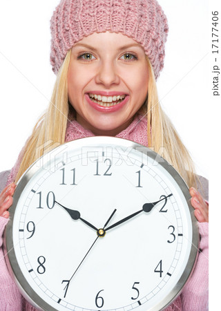 Smiling girl in winter clothes showing clock Smiling girl in winter clothes showing clock 17177406