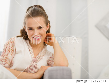 Portrait of smiling young housewife in living room Portrait of smiling young housewife in living room 17177671