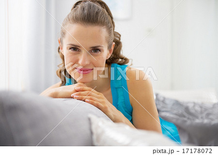 Portrait of happy young woman sitting in living room Portrait of happy young woman sitting in living room 17178072