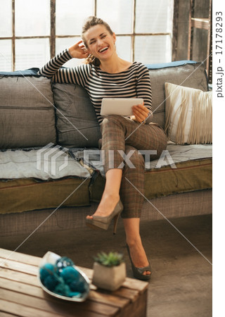 Portrait of smiling young woman with tablet pc sitting in loft a Portrait of smiling young woman with tablet pc sitting in loft a 17178293