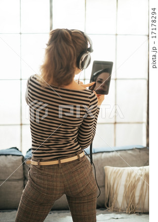 Young woman listening music in headphones in loft apartment. rea Young woman listening music in headphones in loft apartment. rea 17178294