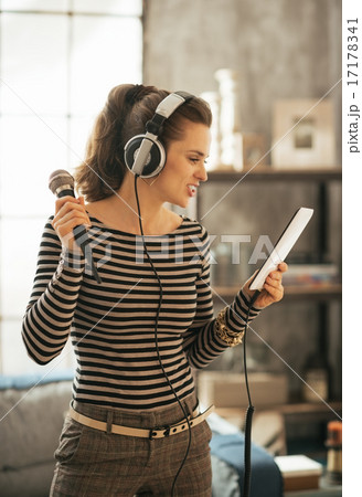 Young woman with tablet pc singing karaoke 17178341