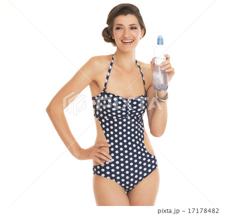 Portrait of happy young woman in swimsuit showing bottle of wate 17178482