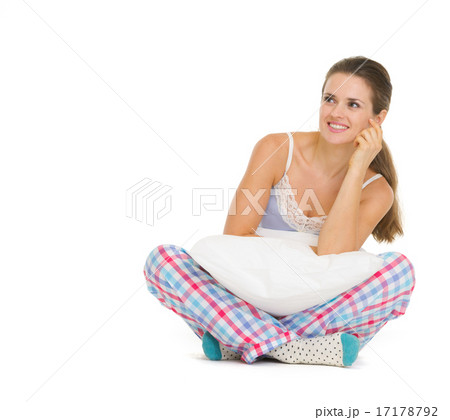 Happy young woman in pajamas sitting with pillow Happy young woman in pajamas sitting with pillow 17178792