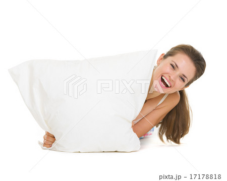 Woman looking out from pillow isolated on white 17178818
