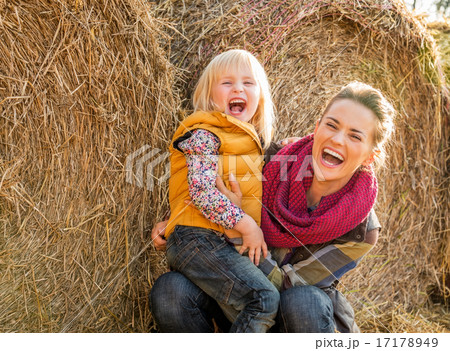 Portrait of smiling mother and child near haystack 17178949