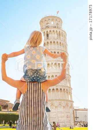 Baby girl sitting on mothers shoulders and looking on leaning to 17178975